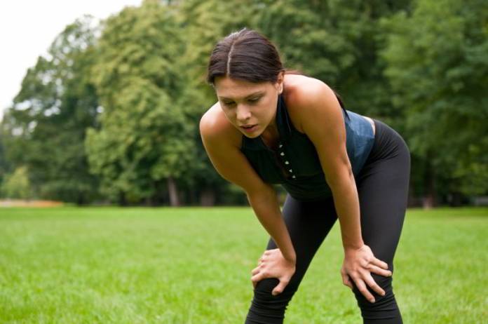 Motywacja do treningu - zmęczona kobieta po bieganiu w parku